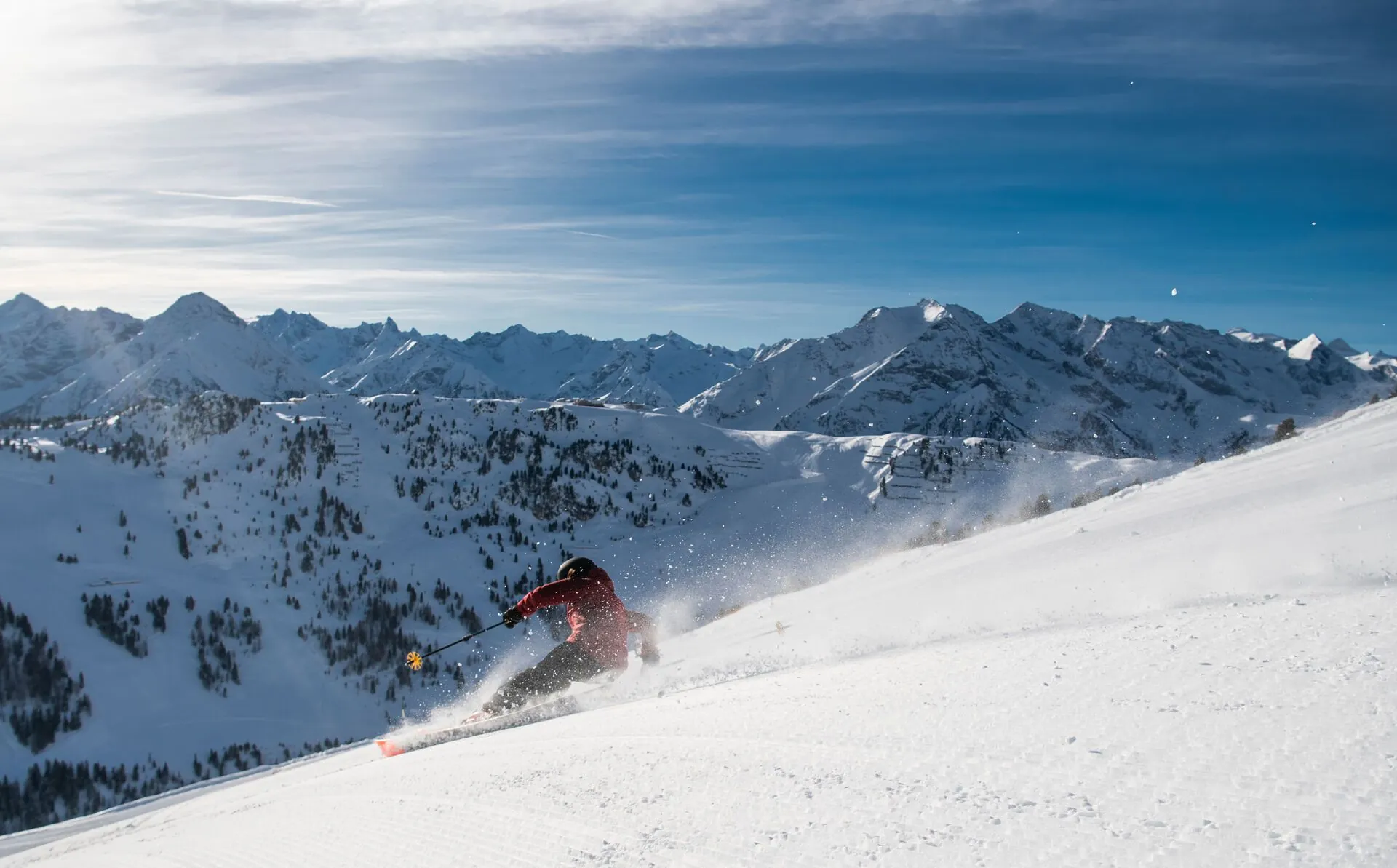 Ski&euml;r op een brede piste met bergen op de achtergrond bij Mayrhofen
