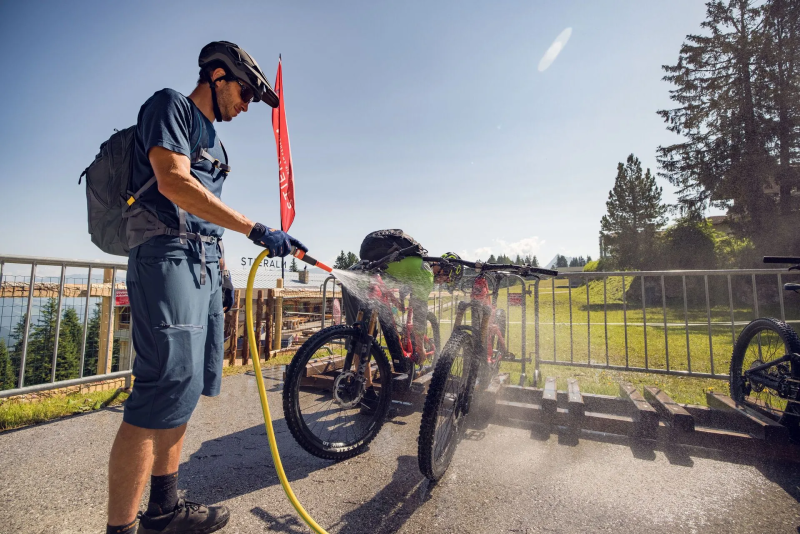Mountainbiker maakt zijn fiets schoon bij een bikewash in Mayrhofen
