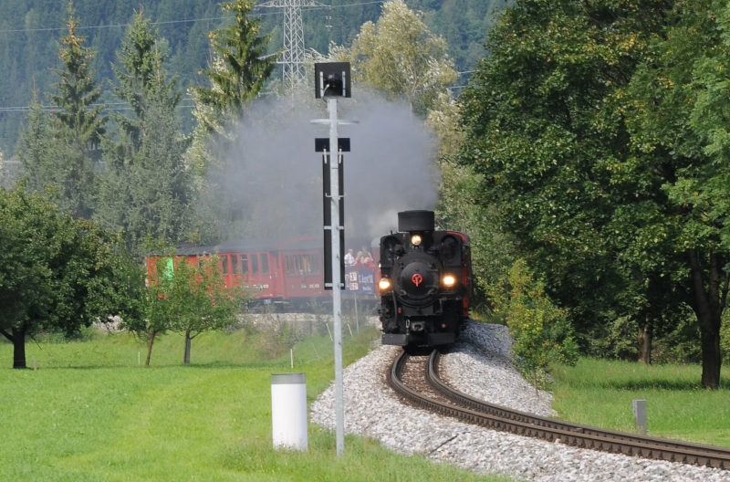 Stoomtrein van de Zillertalbahn rijdt door het groen
